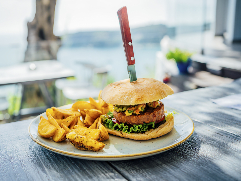 burger and potato wedges on an outdoor restaurant table