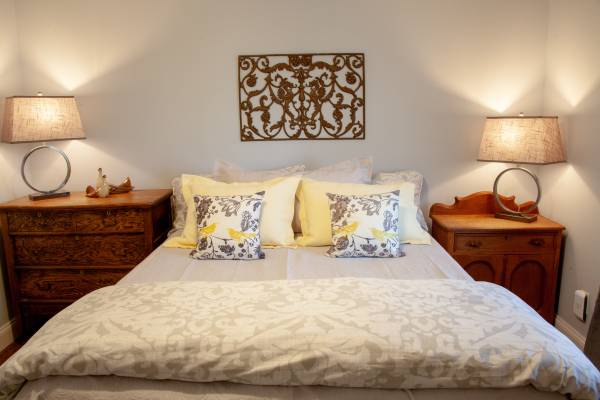 bed with yellow pillows in between two side dressers with lamps