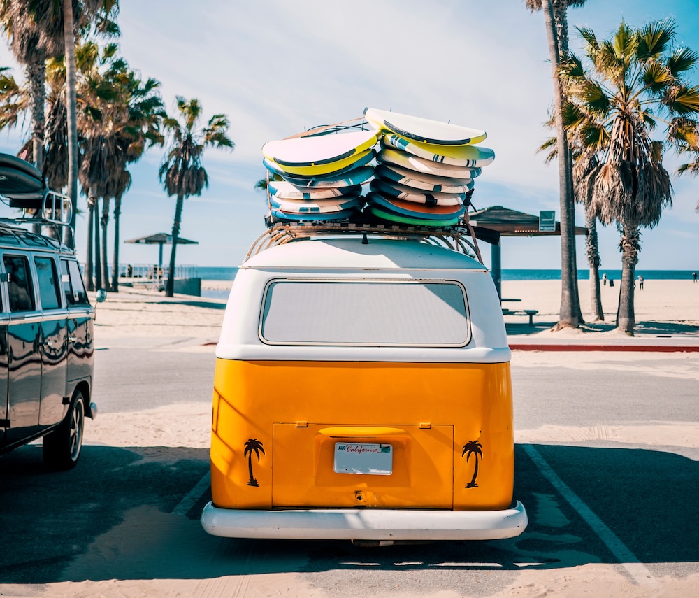 brightly colored van with surf boards on top of it