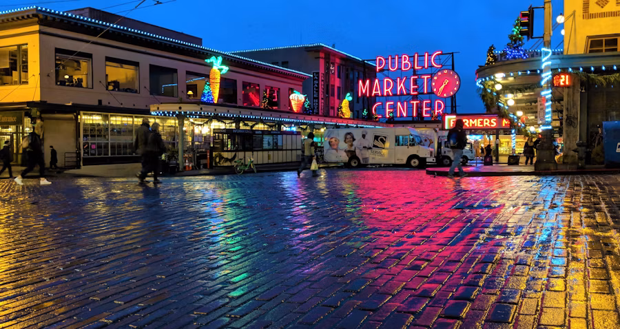 Pike Place Market neon reflected on a wet street at night in Seattle