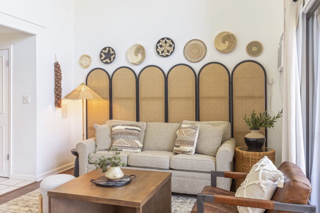 Sitting area in a Perch-managed Maui condo with woven wall decor and a neutral sofa