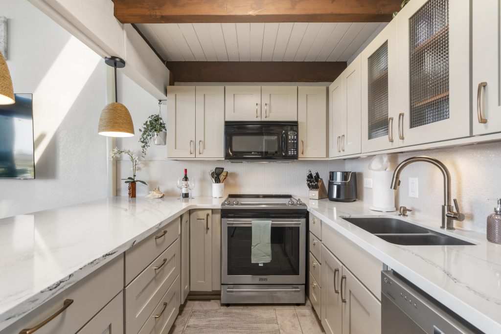 Kitchen in a Perch-managed Maui condo with white cabinets and a stainless range