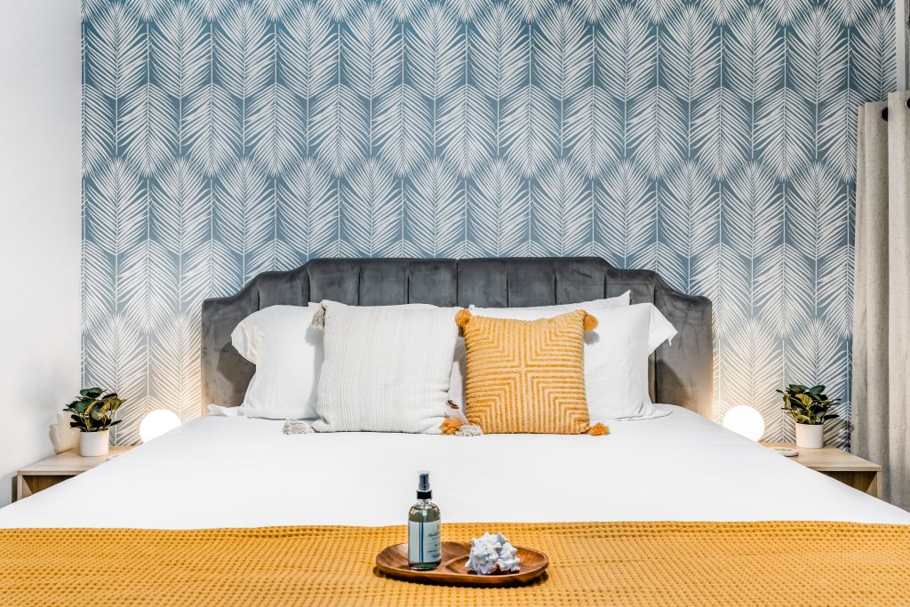 Bedroom in a Perch-managed Maui condo with patterned wallpaper and white bedding