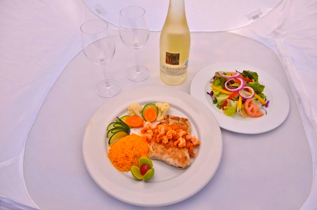 Cantina Juanitos cenando con plato de ensalada y botella de vino