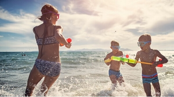 niños de vacaciones en San Felipe jugando con pistolas de agua