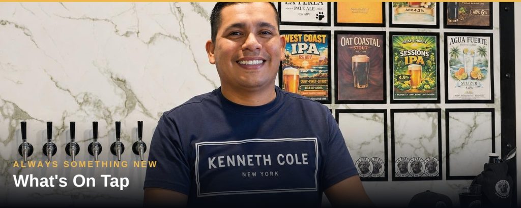 Pared de grifos de la cervecería La Perla con pizarra de menú de cervezas, San Felipe
