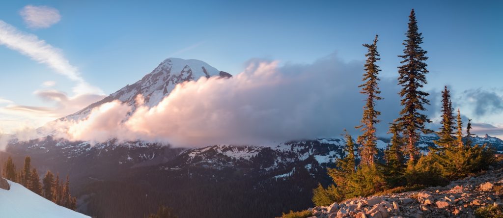 Mount Rainier towers over the surrounding mountains sitting at an elevation of 14,411 ft. It is considered to be one of the world's most dangerous volcanoes. Spring time, sunny day. Washington, USA