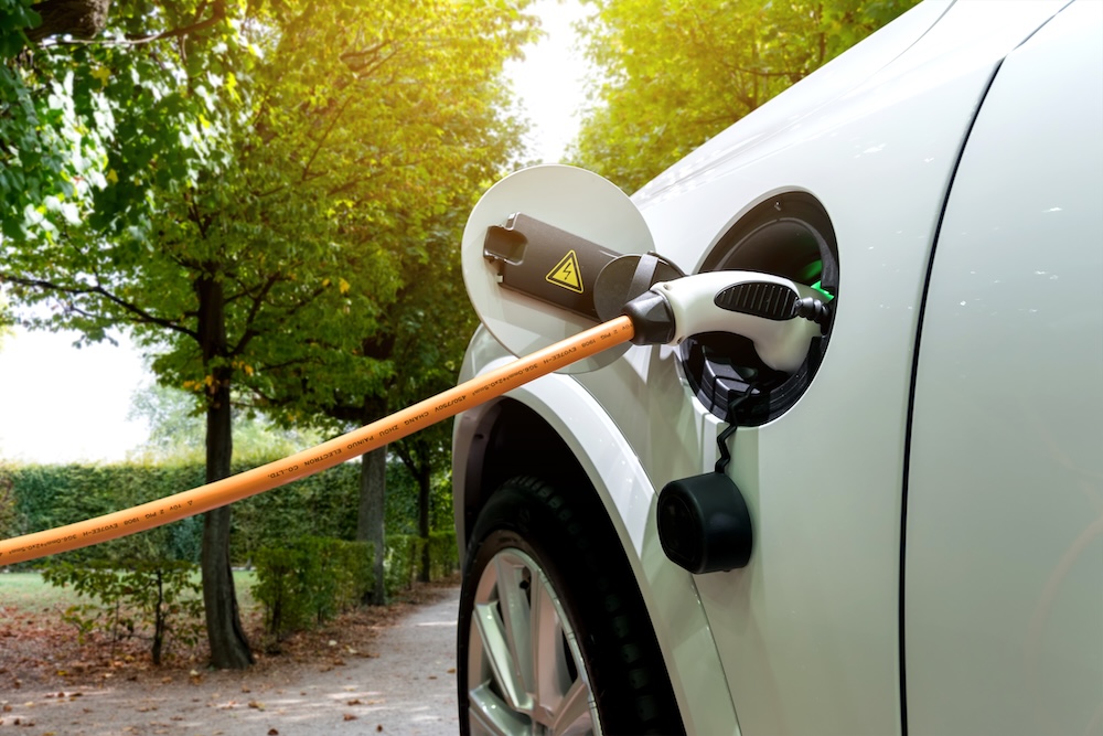 Charging an electric car with the power cable supply plugged in.